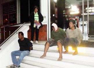 Officers detain the three suspects on the front steps of the police station.